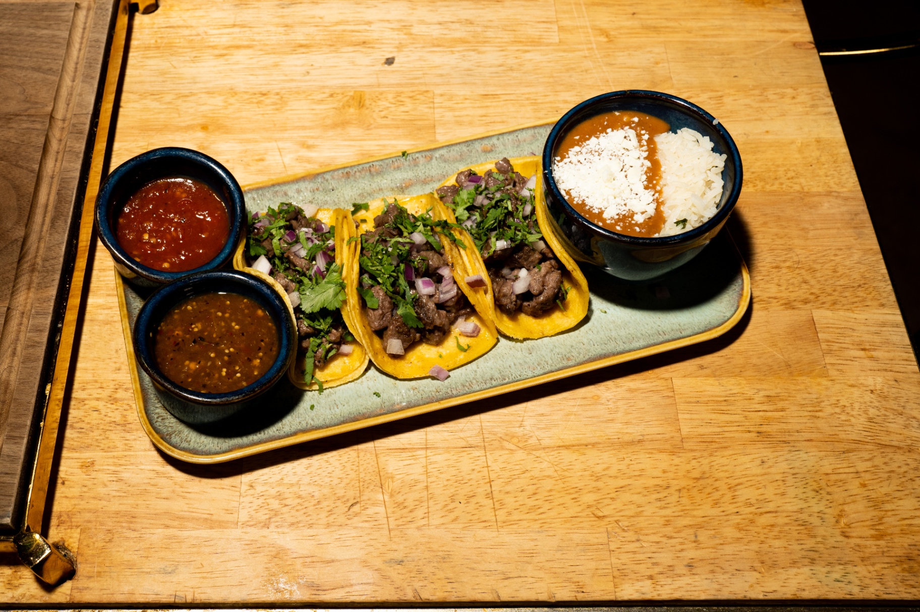 Carne asada street tacos with salsa trio and frijoles charros